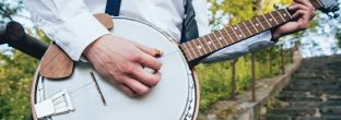 closeup of musician playing banjo in park