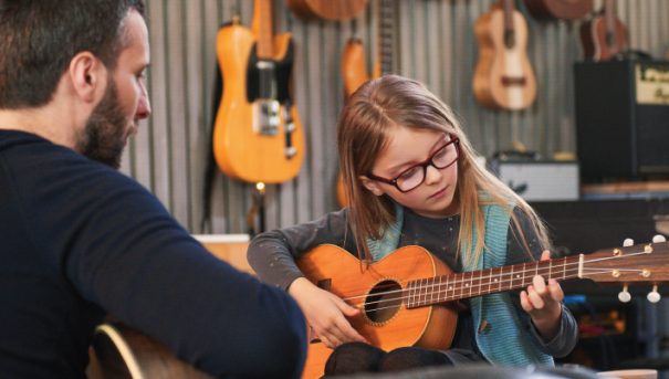 young girl receiving qualified instruction on how to play the ukulele